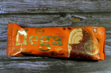 Photo for Cairo, Egypt, July 15 2023: Nestle Mega Salted Caramel ice cream stick coated and covered with a layer of dark chocolate with nuts, Rich flavored ice cream in cracking chocolate crunch, roasted almond - Royalty Free Image