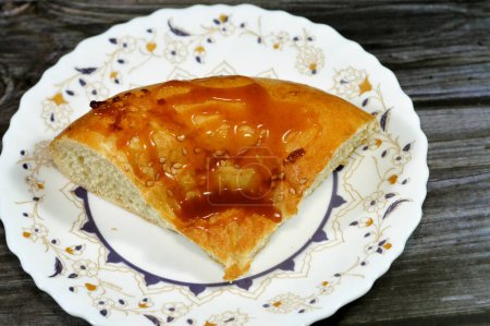 Téléchargez les photos : Sauce caramel garniture sur un tandyr nan pain ouzbek, un type de pain d'Asie centrale, souvent décoré par des motifs d'estampillage sur la pâte à l'aide d'un timbre de pain connu sous le nom de chekich, également appelé tamdyr - en image libre de droit