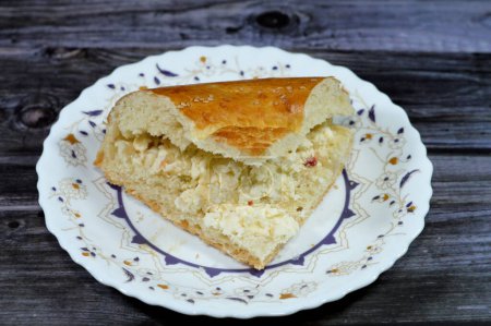 Téléchargez les photos : Fromage blanc à l'intérieur d'un morceau de pain tandyr nan ouzbek, un type de pain d'Asie centrale, souvent décoré par des motifs d'estampillage sur la pâte à l'aide d'un timbre de pain connu sous le nom de chekich, également appelé tamdyr - en image libre de droit