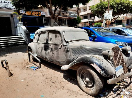 Foto de El Cairo, Egipto, 1 de agosto de 2023: Antiguo automóvil retro vintage estacionado en la calle con una nueva placa de tráfico egipcia número de letras y números, viejo coche abandonado oxidado en la calle - Imagen libre de derechos
