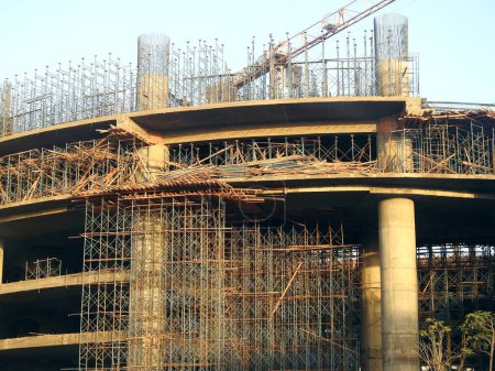 Foto de Un sitio de construcción de un nuevo edificio, con torre de grúa, andamios metálicos, estructuras de cemento, columnas de hormigón y acero, uno de los proyectos inmobiliarios en Egipto, nuevos edificios, gran altura en El Cairo - Imagen libre de derechos