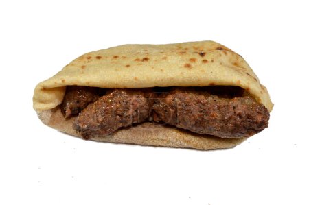 Photo for Arabic cuisine traditional food beef Kofta, kebab and tarb kofta shish, minced meat wrapped in lamb fat charcoal grilled and served in flatbread sandwich, oriental grilled barbecued meat food - Royalty Free Image