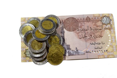 Foto de Pilas de 1 LE EGP una libra egipcia monedas en efectivo y 50 cincuenta piastras egipcias media libra monedas en un billete de libra egipcia aislado sobre fondo blanco, Egipto concepto de tipo de cambio - Imagen libre de derechos