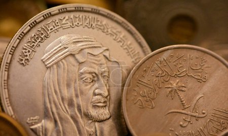 An old vintage retro Saudi Arabia coin at the Era of king Faisal, An Egyptian One 1 LE EGP silver pound coin with the slogan of King Faisal Bin AbdulAziz Al Saud, commemorative coin after his death
