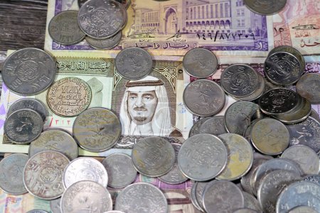 Photo for Saudi Arabia riyals money banknote bills and coins of different eras from the kingdom of Saudi Arabia times, vintage retro old Saudi currency, value, exchange rate of the currency, old coins - Royalty Free Image