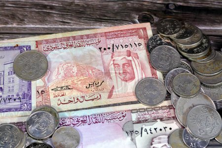 Photo for Saudi Arabia riyals money banknote bills and coins of different eras from the kingdom of Saudi Arabia times, vintage retro old Saudi currency, value, exchange rate of the currency, old coins - Royalty Free Image