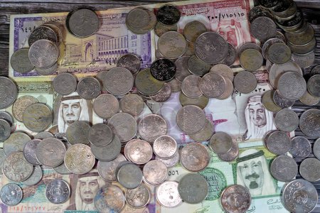 Foto de Arabia Saudita riales billetes de banco y monedas de diferentes épocas del reino de Arabia Saudita tiempos, moneda antigua retro Arabia Saudita, valor, tipo de cambio de la moneda, monedas antiguas - Imagen libre de derechos
