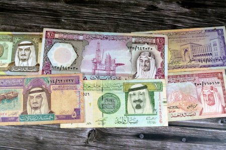 Photo for Old Saudi Arabia riyals money banknote bills of different eras from the kingdom of Saudi Arabia times, vintage retro old Saudi currency, value, exchange rate of the currency, old notes - Royalty Free Image