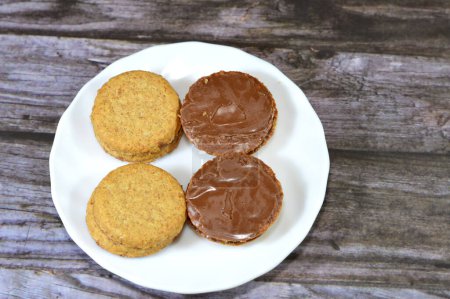 Photo for Chocolate coated oat biscuits, sweet treat during the day as a snack, Oatmeal Biscuits are soft sweet biscuits made from flour, oatmeal, butter, honey, and milk coated with chocolate, selective focus - Royalty Free Image