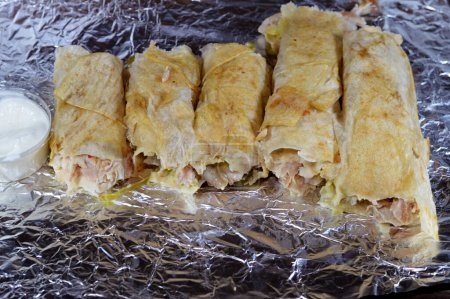Téléchargez les photos : Recette syrienne fond de cuisine, poulet shawerma ou shawarma tortilla envelopper d'oignon, tomate, laitue et sauce à l'ail dans le pain syrien, concept de cuisine arabe, enveloppé shawerma avec tomeya - en image libre de droit