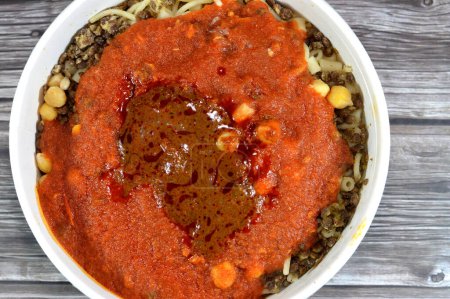 Cocina egipcia de Koshary, una popular comida callejera hecha de arroz, macarrones, espaguetis y lentejas mezcladas juntas rematadas con una salsa de tomate especiado, vinagre de ajo, cebollas fritas y garbanzos hummus