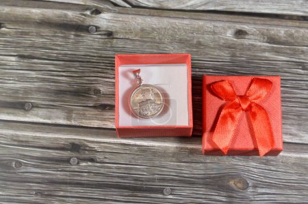 Foto de Un regalo rojo pequeña caja decorada con una moneda libra islámica de metal de plata preciosa pura, 8 gramos 999 características Kaaba y mezquita Masjid Al Haram y los minaretes en La Meca en el reino de Arabia Saudita - Imagen libre de derechos