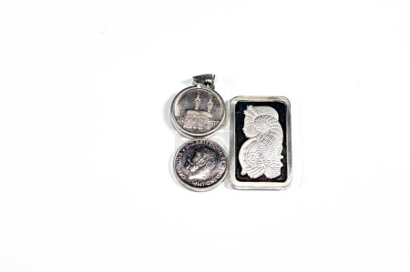 Silver precious metal ounce bar of pure silver, Islamic pound features Kaaba, Masjid Haram and The sovereign, a British silver coin shape, a bullion coin, assorted silver coins and bars precious metal