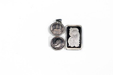 Silver precious metal ounce bar of pure silver, Islamic pound features Kaaba, Masjid Haram and The sovereign, a British silver coin shape, a bullion coin, assorted silver coins and bars precious metal