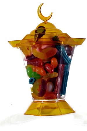 Ramadan lantern fanous lamp with assorted gummy candy, Gummies, gummi candies, gummy candies, or jelly sweets,  gelatin-based chewable sweets. Gummy sour jelly sweets candies in various shapes