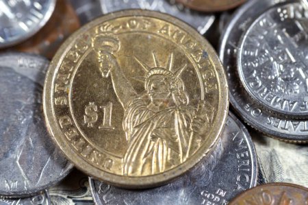 Die Freiheitsstatue auf der Rückseite einer amerikanischen Gedenkmünze aus der Präsidentenserie mit Martin Van Buren 8. Präsident der Vereinigten Staaten von Amerika auf der Vorderseite, auf einem Haufen Münzen