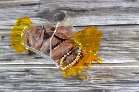 Islamische Laternenfantasien, silberner Rosenkranz und schokoladenüberzogene Datteln sorgen für den besten Snack, Leckerbissen oder Dessert, schmackhafte saudische Datteln, die mit brauner Schokolade überzogen sind, Datteln, die normalerweise im Ramadan verzehrt werden