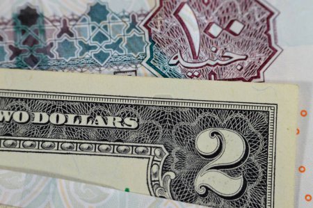 American and Egyptian money banknotes, closeup view of USD United States of America dollars and Egyptian money banknotes of pounds, exchange rate concept, inflation and business background