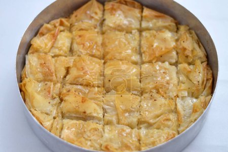 Tablett mit Baklava, einem süßen Dessert aus dem Nahen Osten, das mit Nüssen, Rosinen und geschredderten Kokosnüssen gefüllt und mit Honigzuckersirup, osttürkischer und ägyptischer Baklawa als Dessert im Ramadan-Monat getränkt ist