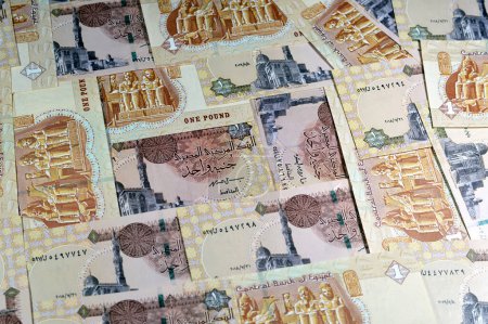 Photo for Pile of 1 LE EGP one Egyptian pound money banknote bill with the main entrance to the Great Temple at Abu Simbel on reverse side and Sultan Qaitbay mosque at left center on the obverse side - Royalty Free Image