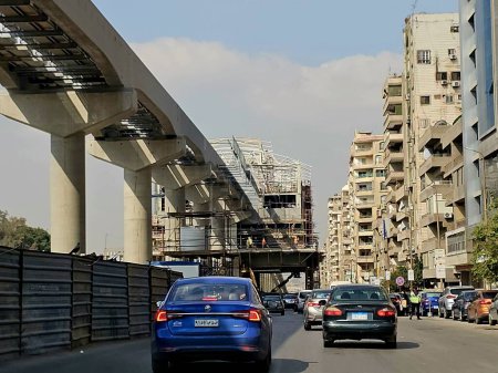 Foto de El Cairo, Egipto, 25 de marzo de 2024: Un sitio de estación de monorraíl que está en construcción con andamios y grúas, el monorraíl de El Cairo es un sistema de tránsito rápido monorraíl de dos líneas actualmente en construcción. - Imagen libre de derechos