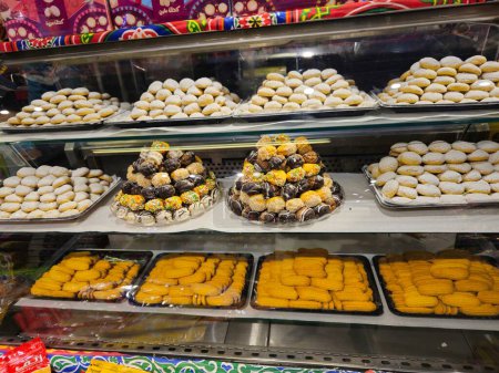Téléchargez les photos : Le Caire, Égypte, 24 mars 2024 : biscuits arabes traditionnels pour la célébration des fêtes islamiques Fête d'El-Fitr, Ghoriba égyptienne, Kahk égyptien au sucre en poudre, petit four (mignardises) au chocolat - en image libre de droit