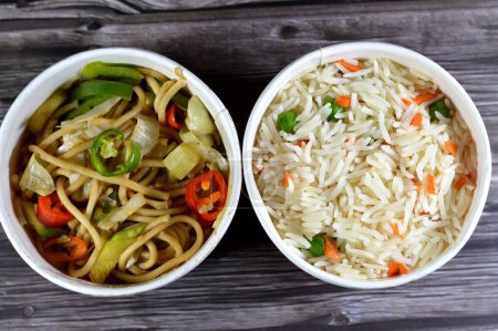 Nudeln und Reis in der asiatischen Küche, chinesisches Essen, langkörniger weißer Basmati-Reis mit Gemüse Möhren und Erbsen und chinesische Nudeln mit Zwiebeln und Sojasauce, traditionelle asiatische chinesische Küche