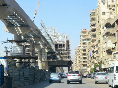 Foto de El Cairo, Egipto, 4 de abril de 2024: Un sitio de estación de monorraíl que está en construcción con andamios y grúas, el monorraíl de El Cairo es un sistema de tránsito rápido monorraíl de dos líneas actualmente en construcción. - Imagen libre de derechos