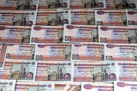 A pile of Egyptian money banknotes of 50 LE fifty pounds features Abu Hurayba Mosque on obverse side and n image of temple of Edfu, winged scarab and a pharaonic boat on the reverse, old series