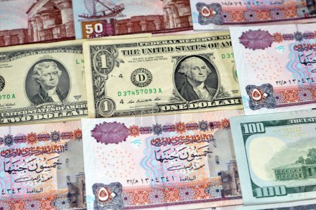 stack of Egypt money banknote bills of 50 EGP LE fifty Egyptian Pounds on USA American dollars currency notes, Egyptian and United states currency exchange rate, Egypt economy status concept