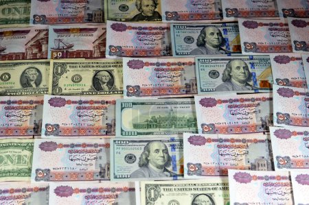 stack of Egypt money banknote bills of 50 EGP LE fifty Egyptian Pounds on USA American dollars currency notes, Egyptian and United states currency exchange rate, Egypt economy status concept
