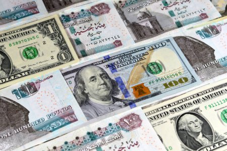 The Egyptian money banknotes of 100 EGP LE one hundred pounds bill and USD American cash of dollars bills, money exchange rates of Egypt and United states of America, inflation and economy concept