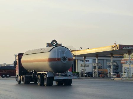 Téléchargez les photos : Le Caire, Égypte, 17 mai 2024 : Un gros camion avec un réservoir contenant des produits pétroliers, un camion sur l'autoroute avec un conteneur sur lui livrant les produits à la station-service d'essence - en image libre de droit