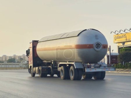 Foto de El Cairo, Egipto, 17 de mayo de 2024: Un camión grande con un tanque de contenedores con productos derivados del petróleo, un camión en la carretera con un contenedor en el que entrega los productos a la gasolinera - Imagen libre de derechos