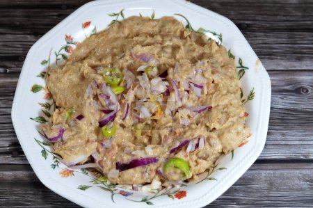 Foto de Mashed fava beans mixed with oil, sesame tahini, cumin, spices, slices of chili pepper and onion, traditional popular Egyptian fava bean done the Alexandrian way of Alexandria city of Egypt - Imagen libre de derechos