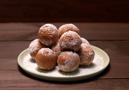 Delicious Donuts, Zeppole Or Paczki On Plate With Powdered Sugar On Wooden Table. Fat Thursday Carnival or Tlusty Czwartek Celebration, Christian tradition. Doughnut, Horizontal Plane