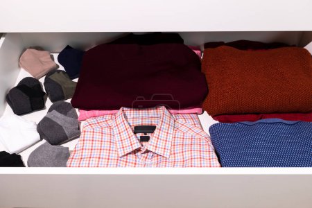 Photo for Shelf With Male Warm Clothes, Outfit in Drawer Of Closet. Folded Fresh Shirt, Sweaters, Socks. Mans Clothing Storage. Wardrobes And Cabinetry. National Clean Your Room Day. Horizontal Plane - Royalty Free Image