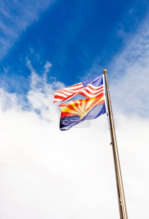 Design Waving American USA Flags and Flag of Arizona State on Flagpole On Background Of Blue White Sky, Template Vertical Plane, Copy Space. High quality photo