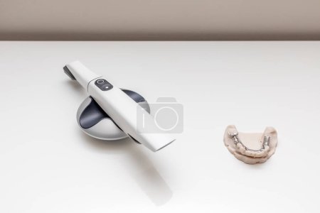 Bridge Printed By 3d Printer on Table. 3D Intraoral Teeth Scanner For Imaging Tooth and Metal Frame Lower Partial Denture, Cobalt Chrome Dental Plate. No People. Dental Equipment, Device, Dentistry