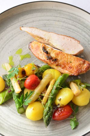 grilled chicken breast with vegetable side dish, served food in a restaurant on a plate