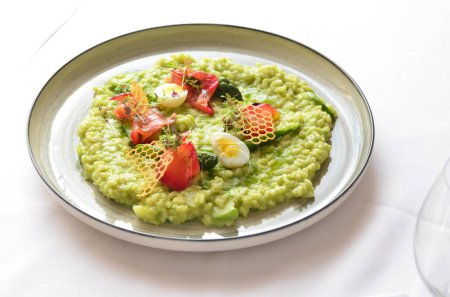 Photo for Close view of healthy super food vegetarian green risotto and fresh micro herbs, smoke salmon - Royalty Free Image