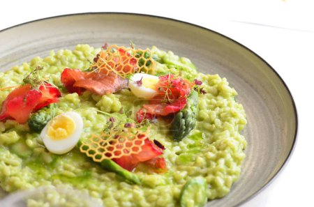 Photo for Close view of healthy super food vegetarian green risotto and fresh micro herbs, smoke salmon - Royalty Free Image