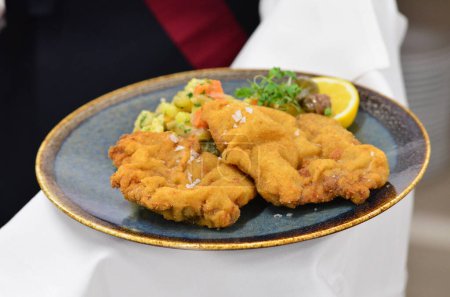 deep fried fish on plate in restaurant, view of served veal steak from liver, Czech traditional food, restaurant background, close-up view