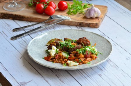 lamb stewed with tomatoes and orzo, background of greek traditional food youvetsi