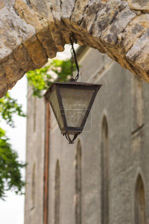 Photo for Antique street lantern hanging in stone arch at the entrance to the old mountain castle, Poland. Old street light against medieval architecture. Details of historic gas lamp. European tourism concept - Royalty Free Image