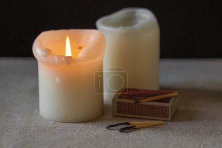 Téléchargez les photos : Deux bougies à la paraffine brûlent dans l'obscurité, comme sources alternatives de lumière et de chaleur. Panne d'électricité en Ukraine en raison de la guerre. Crise énergétique en Europe. Manque de chauffage et d'électricité dans les villes ukrainiennes. - en image libre de droit