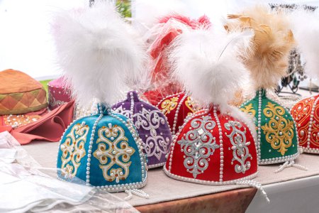 Téléchargez les photos : Coiffes traditionnelles pour les filles du Kazakhstan et d'Asie centrale avec des plumes sont vendus sur un stand de rue - en image libre de droit