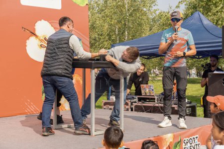 Foto de Almaty, Kazajstán 17 de septiembre de 2023. Un hombre derrotó a otro en la lucha libre de brazos sujetando su mano a la mesa. - Imagen libre de derechos