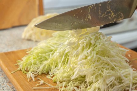 Dünn geschnittenes Weißkraut für die Zubereitung von Salat. Selbstgemachtes. Veganismus und Rohkost-Ernährungskonzept.