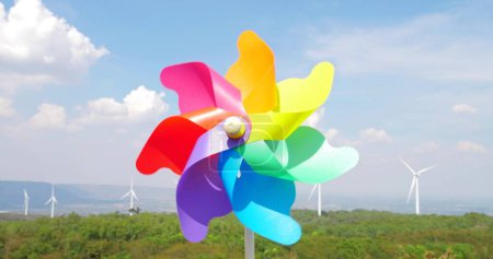 Photo for Close up colorful windmill toy on natural mountain with high wind turbine park and blue sky background - Royalty Free Image